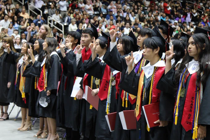 Students singing their Alma Mater on the arena floor after the ceremony.