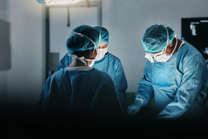 A surgical team performs a procedure in theatre.