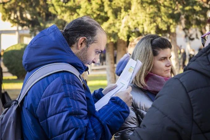 Foto de varias personas con discapacidad intelectual consultando documentación