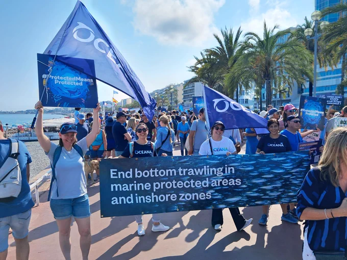 Oceana members hold a banner calling for ending bottom trawling in marine protected areas