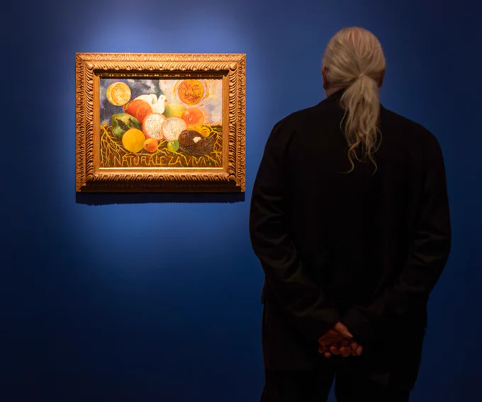 A museum visitor viewing a painting by Frida Kahlo in VMFA's special exhibition "Frida: Beyond the Myth."