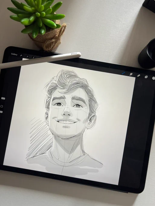 Pencil sketch of a smiling boy on a digital tablet screen.