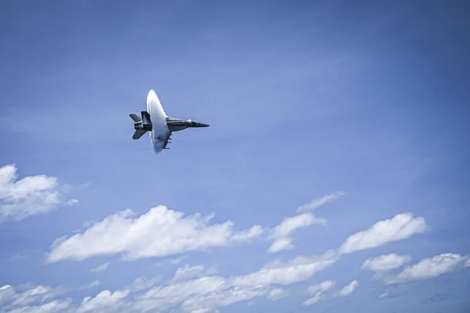 An F/A-18E Super Hornet from the “Kestrels” of Strike Fighter Squadron (VFA) 137 breaks the sound barrier near the aircraft carrier USS Nimitz (CVN 68) in the South China Sea, May 27, 2025. The Nimitz is underway in the U.S. 7th Fleet area of operations on a scheduled deployment, demonstrating the U.S. Navy's unwavering commitment to a free and open Indo-Pacific. (U.S. Navy photo by Mass Communication Specialist 2nd Class Hannah Kantner)