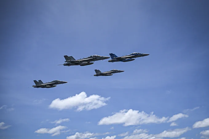 U.S. Navy aircraft fly near the aircraft carrier USS Nimitz (CVN 68) in the South China Sea, May 27, 2025. The Nimitz is underway in the U.S. 7th Fleet area of operations on a scheduled deployment, demonstrating the U.S. Navy's unwavering commitment to a free and open Indo-Pacific. (U.S. Navy photo by Mass Communication Specialist 2nd Class Hannah Kantner)