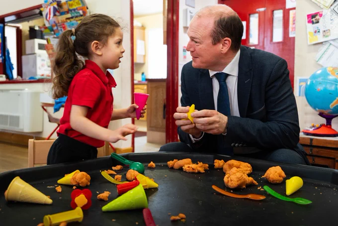 Minister Lyons and a child playing with Play-Doh.