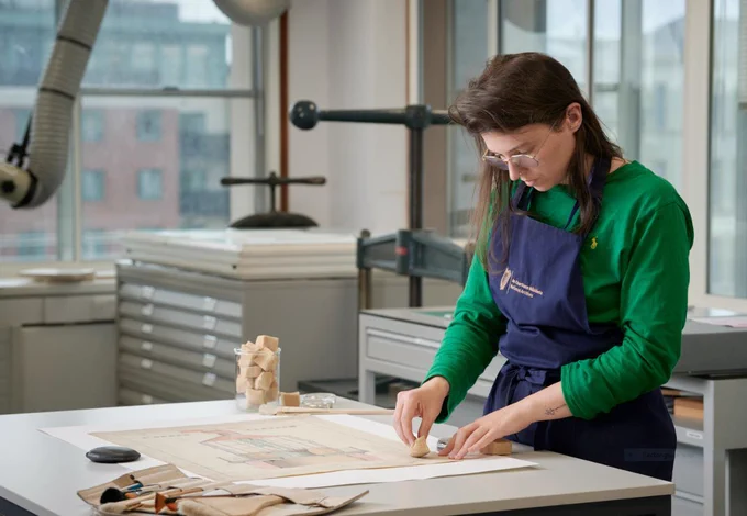 Our conservator cleans a document with a smoke sponge