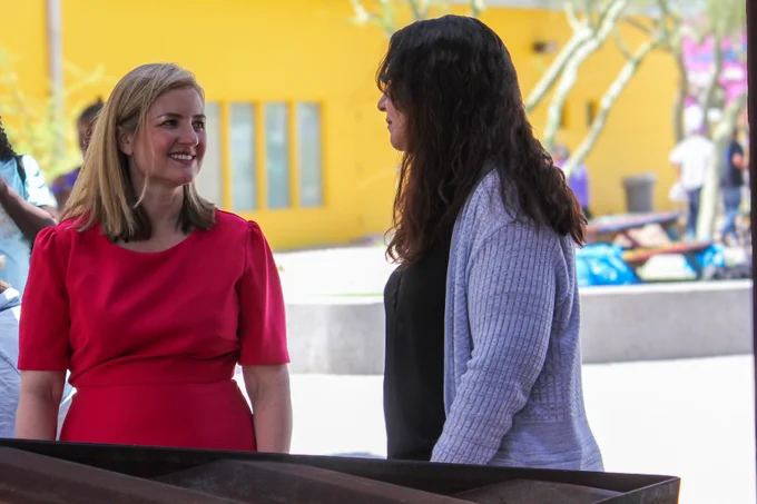 Two individuals in conversation outdoors.