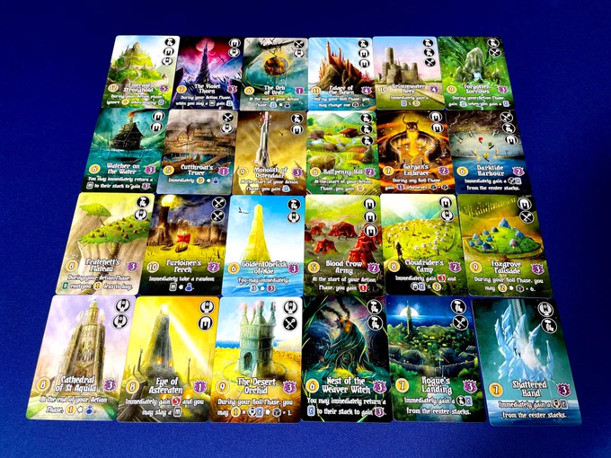 A 4x6 grid of 'domain' cards from Valeria Card Kingdoms. These cards have illustrations of different areas with buildings and have names such as Nest of the Weaver Witch or Rogue's Landing.