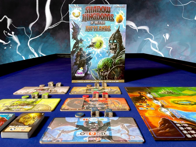 The box for the board game expansion Riftlands atop a table with lightning in the background. In front of the box are the game components which include a game board, cardboard player board add-ons, tokens and cards.