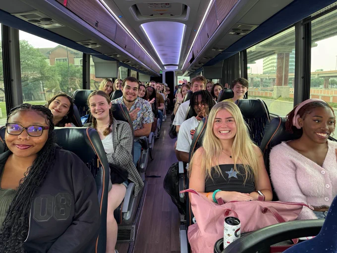 a group of students take a photo on a bus