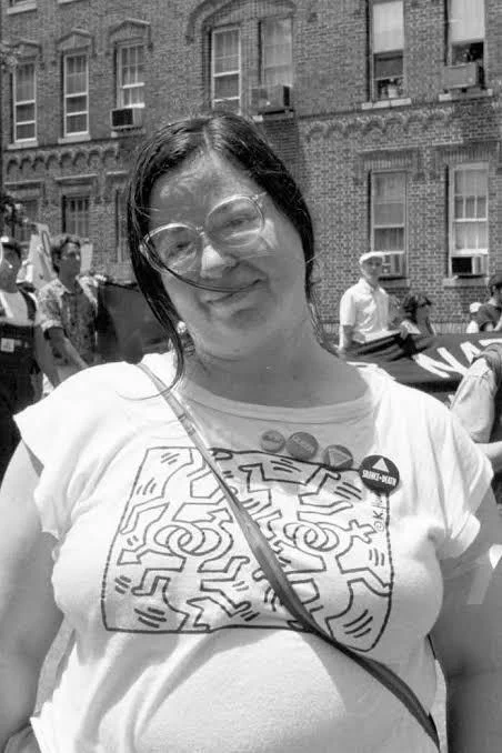 A black and white picture of Brenda Howard wearing a bright pink button that perhaps said it all: "Bi, Poly, Switch- I know what I want."