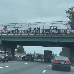 "medicaid cuts fund billionaires" sign above i-93 in danvers, ma during friday's afternoon commute