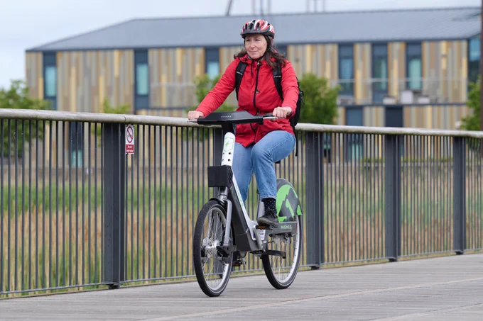 Woman cycling over a bridge