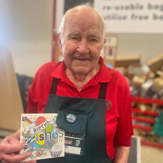 Harold, a Bunnings Warehouse employee holding a 'Birthday Wishes' card.