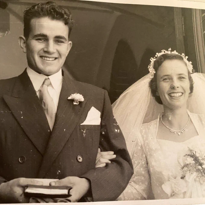 Harold and his wife Margaret, wedding photo with Harold wearing a suit and holding a book, and Margaret in a bridal gown and tiara.