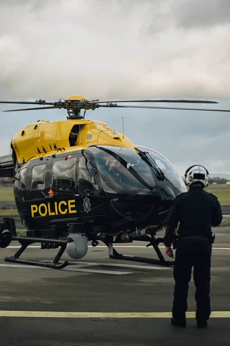A police helicopter with the pilot giving an observer a thumbs up during the start up procedure
