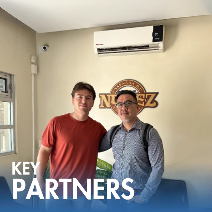 A C.A.T. Global SATX representative pictured with a carrier partner inside an office, showcasing a strong partnership and ongoing collaboration.