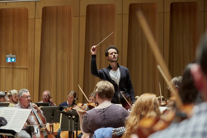 A conductor conducts an orchestra 