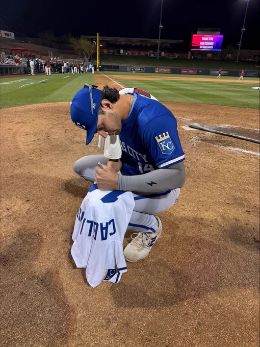 Photo of Jac Caglianone signing his jersey on the field
