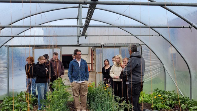 Group of people in a polytunnel. 