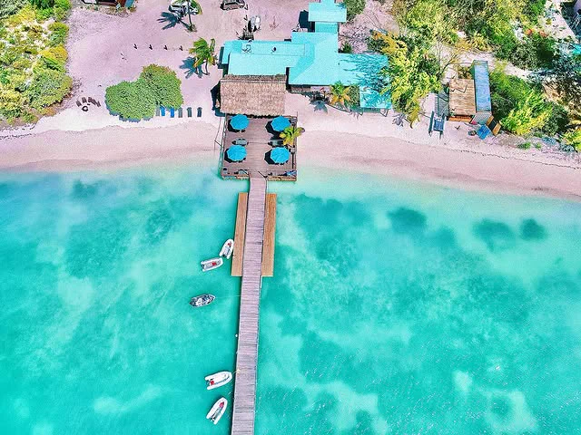 Aerial views of the Lobster Trap Restaurant and dock surrounded by the beautiful blue turquoise waters of Anegada, in the British Virgin Islands. 