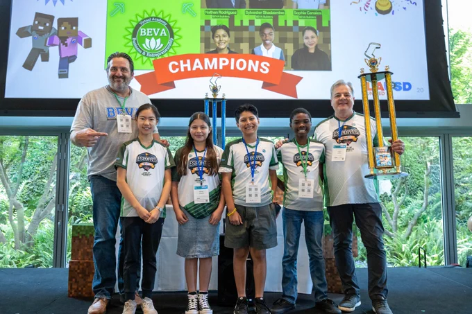 Photograph of Middle School Division champions wearing esports jerseys and holding up their trophy.