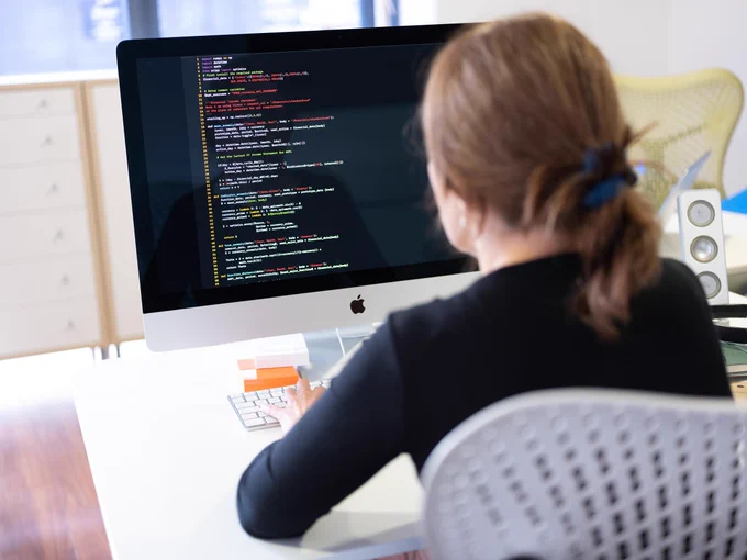 Photo of a woman working at a computer.