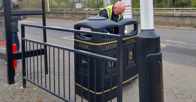 A wandsworth street bin being emptied by a member of staff