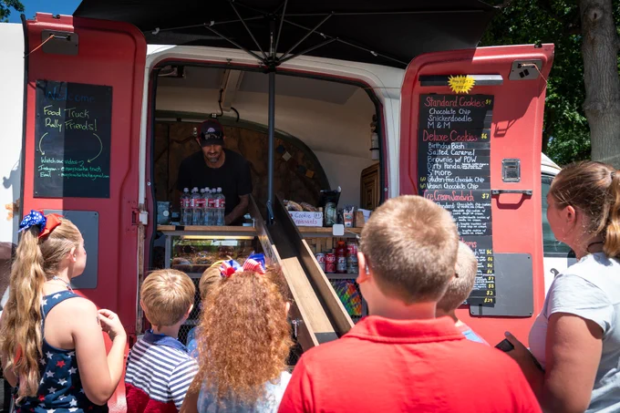 Children lined up to get treats from a food truck