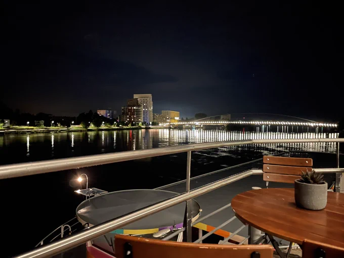 view from a balcony onto a river with a illuminated bridge in the background