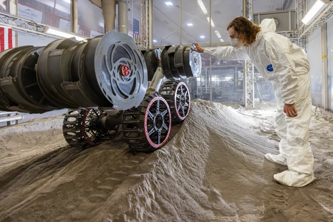 Ben Burdess, mechanical engineer, observes NASA’s RASSOR (Regolith Advanced Surface Systems Operations Robot) excavation testing of simulated regolith, or lunar dust found on the Moon’s surface, inside of the Granular Mechanics and Regolith Operations Lab at the agency’s Kennedy Space Center in Florida on Tuesday, May 27, 2025. RASSOR is designed to work in low-gravity situations, using counter rotating bucket drums on each arm to collect and dump regolith for the extraction of hydrogen, oxygen, or water, resources critical for sustaining a habitable presence. Photo credit: NASA/Frank Michaux