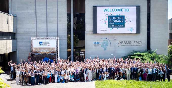 The picture of a large group of people attending EBW25, outside of Palazzo dei Congressi in Bologna, Italy. They are all waving at the camera.