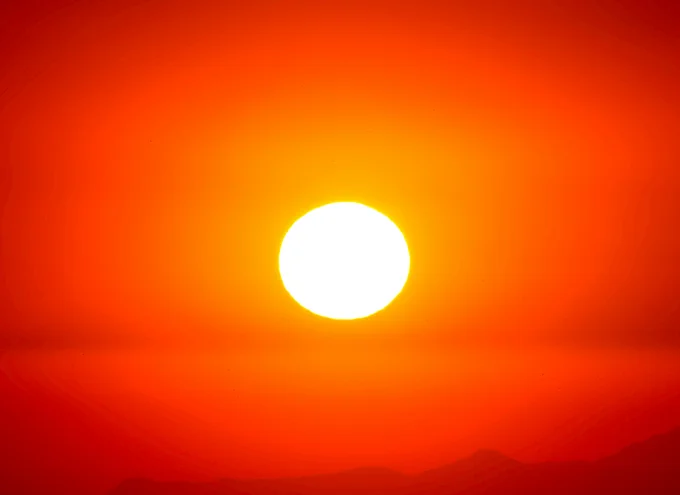 A glowing sun in an orange-red sky.