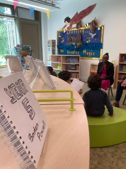 a group of children sitting around a table in a library