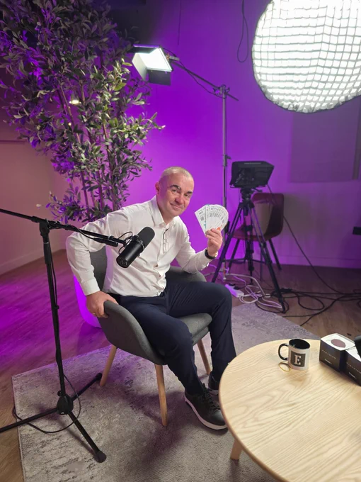 Tectum CEO sitting at an interview set holding SoftNote bills. 