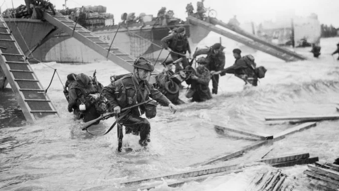 Black and white photograph of Royal Marine Commandos making their way onto the 'Nan Red' sector of Juno Beach, 6 June 1944.