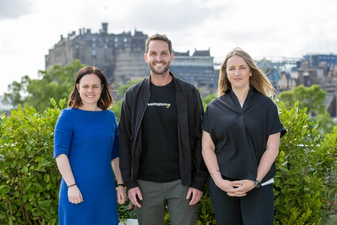 From left to right image shows Deputy First Minister Kate Forbes MSP, Humanitix co-founder and co-CEO Adam McCurdie, and Visibility Scotland CEO Laura Walker standing together smiling.
