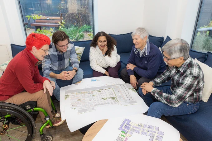 Five members of the patient advisory group, looking at plans for the new hospital.
