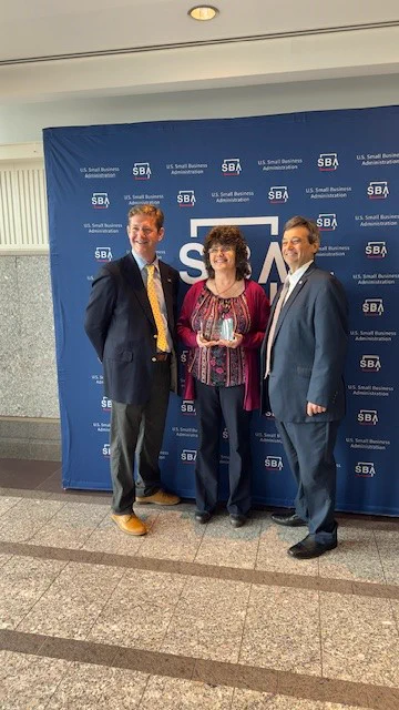 SBA Regional Administrator Matt Coleman (left) and SBA Metro New York District Director John Mallano (right) present the 2025 SBA Metro New York District Women's Business Center of Excellence Award to the Mid-Hudson WBC and its director, Cynthia Marsh-Croll.