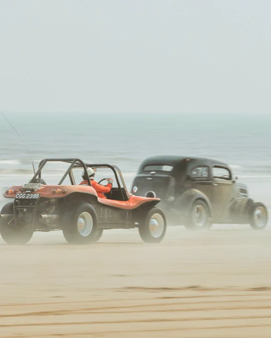 Two cars racing along Bridlington's south beach during the Race the Waves event.