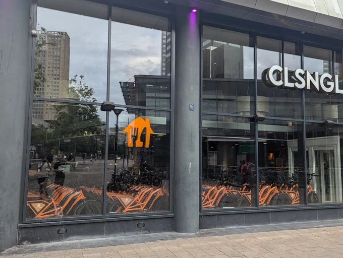 A building with a Just Eat / Takeaway.NL logo filled with several orange branded bikes.