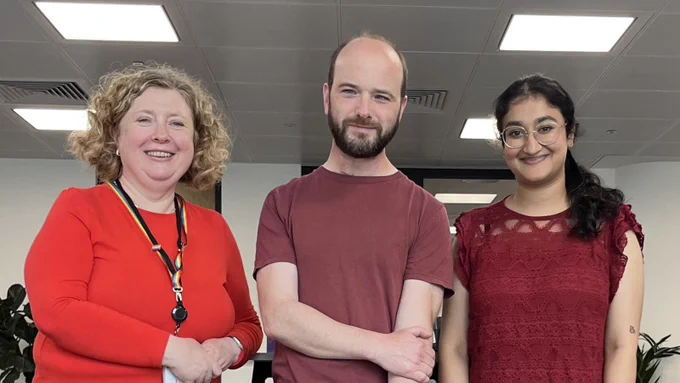 Three people wearing red clothing to mark #RedforResearch