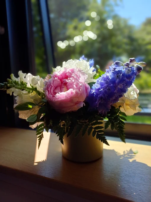 Small flower arrangement in the sun on a windowsill.