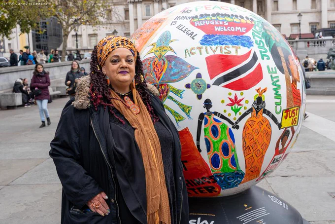 Photo of Zita infront of a globe with "activist" written on it