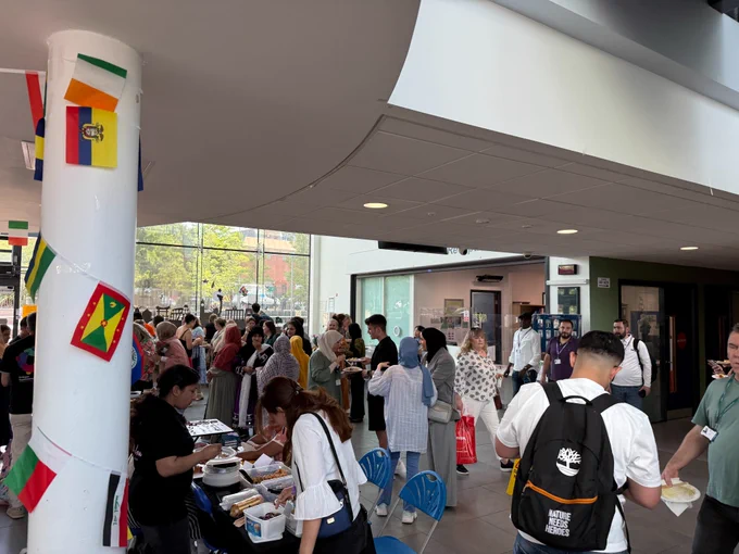 Stalls and crowds of people at St Helens College Refugee Week event