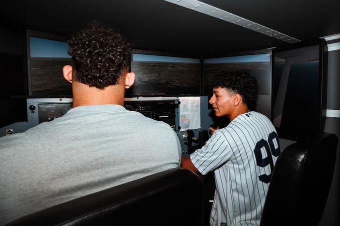Jasson Domínguez in a flight simulator with a student interested in aviation. 