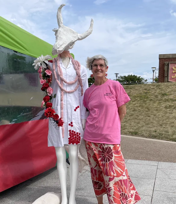 Person stood next to an human-like art project with a deer head