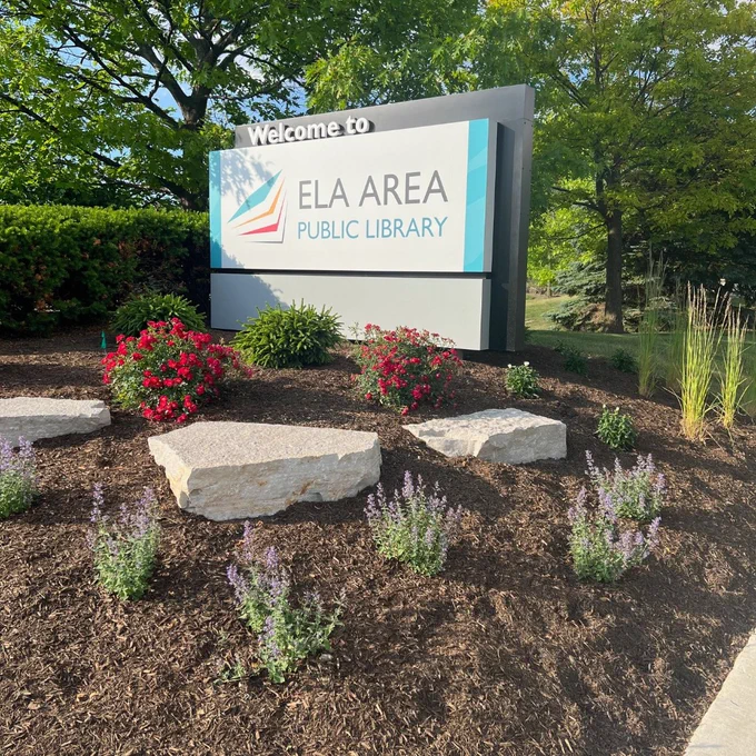Image of plants and the welcome sign at entrance