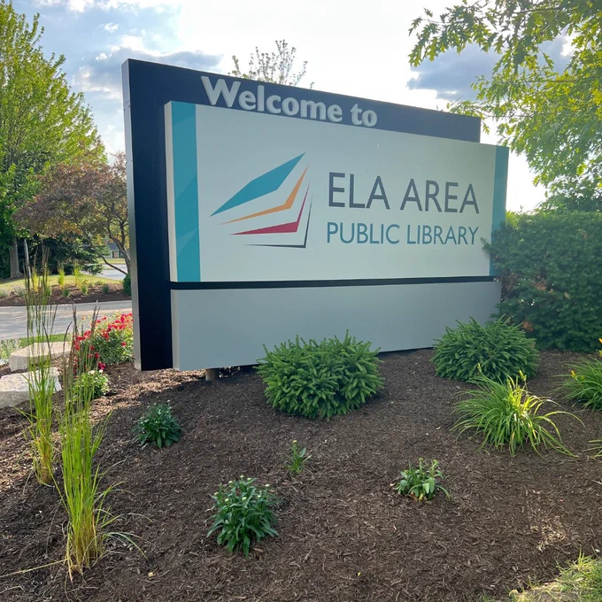Image of plants and welcome sign at the entrance