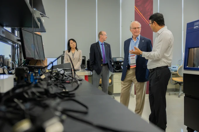 A Virginia Tech engineering member gives Ed Tiedemann a tour of the lab named after him.